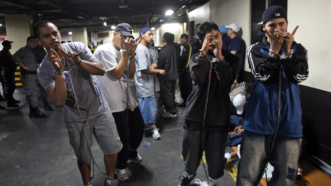 Members of the "Mara Salvatrucha" gang gesture whilst kept in restraints in court in Guatemala City on July 28, 2015. At least three mara members were shot by rival gangsters while they were held under custody in a special jail located in the basement of the Supreme Court building. AFP PHOTO JOHAN ORDONEZ        (Photo credit should read JOHAN ORDONEZ/AFP/Getty Images)