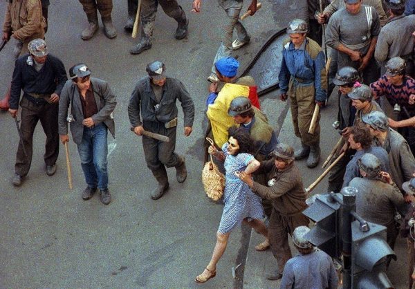 Bányászok egy csoportja egy tüntetővel erőszakoskodik Bukarest központjában az 1990. júniusi bányászjárás idején. Forrás: Andrei Iliescu, AFP/MTI