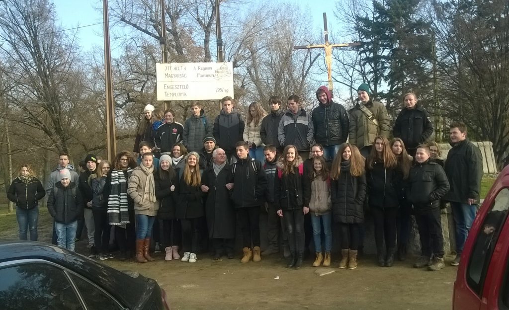 Dénes János az iskolás fiatalok gyűrűjében, a Regnum Marianum emlékhelyénél, 2016 decemberében. A szerző felvétele.
