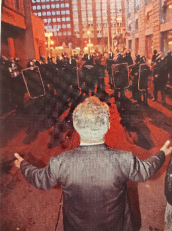 A történelem ismétli önmagát. Dénes János szemben a rohamrendőrökkel 2006. október 23-án a Gerlóczy utcában. Forrás: Dénes János: Körmömszakadtáig (hátsó borító)